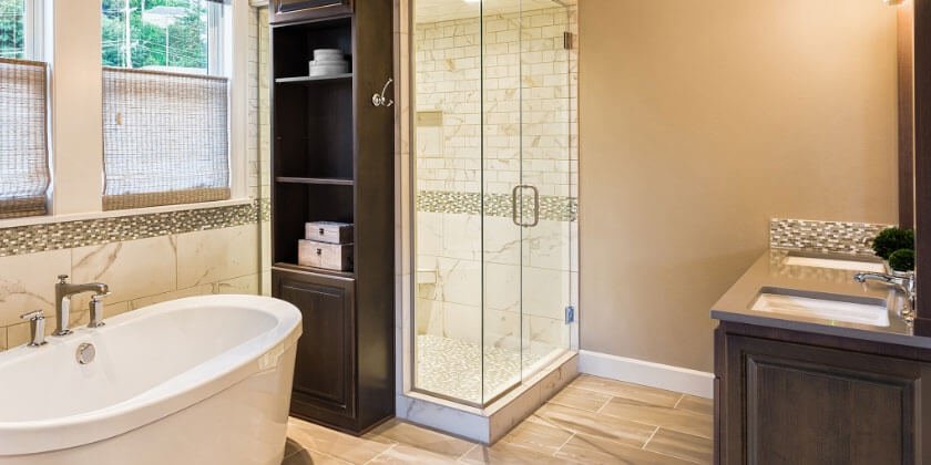 Modern bathroom interior with a freestanding tub, walk-in shower, and dual-tone vanity, expertly designed by a Boston contractor.