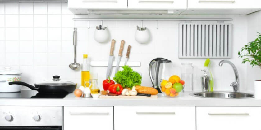 A well-organized kitchen countertop displaying various fresh ingredients and cooking utensils with a stove and sink, recently renovated by a Boston-based construction company.