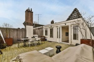 Rooftop terrace with outdoor furniture and a deck built by a reputable deck builder, offering a view of residential building exteriors.